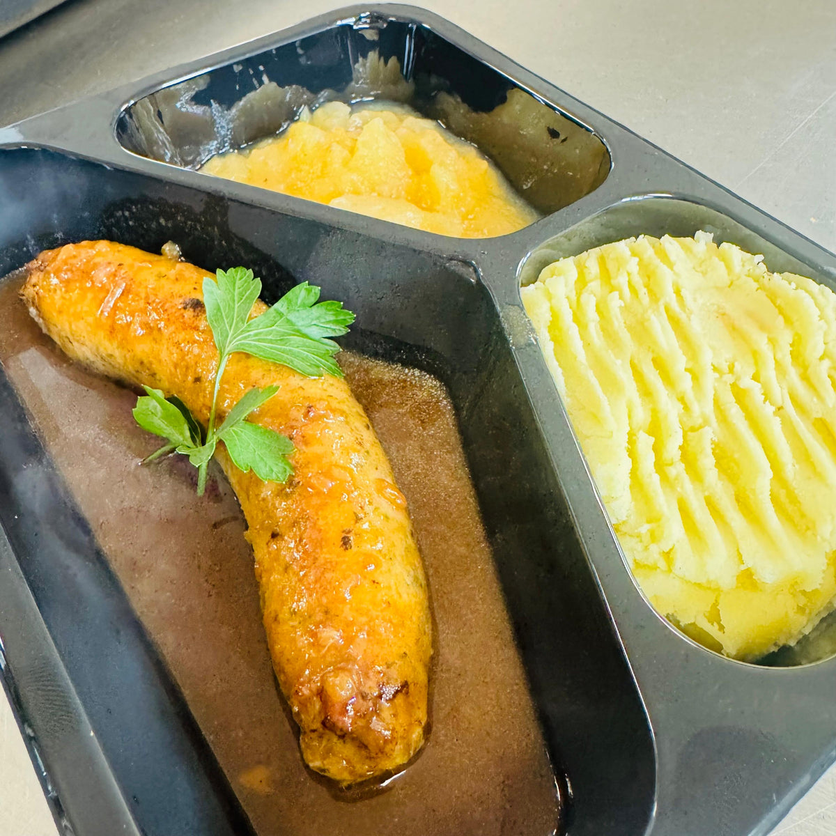 Mardi 03/11: Saucisse de veau, réduction aux oignons, compote de pommes et purée